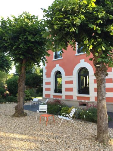 a tree in front of a house with a large window at Le Clos de la Pomponnette in Pomponne
