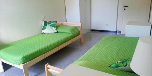 Zimmer mit 2 Betten und grüner Bettwäsche in der Unterkunft Aurelia - Apartment Begonia in Rom
