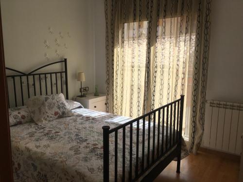 a bedroom with a bed and a window with curtains at Tu apartamento en Ribes de Freser in Ribes de Freser