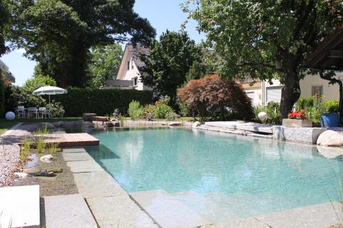 a swimming pool in the backyard of a house at Hotel garni Schacherer in Müllheim