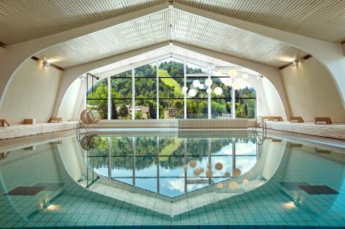 an indoor swimming pool with a view of the water at Hotel Park - Sava Hotels & Resorts in Bled