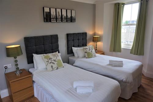 a bedroom with two beds with white sheets at The Angel Hotel in Cardigan
