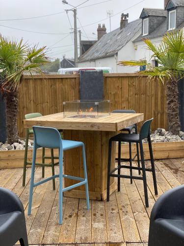 a wooden table and chairs on a patio at la villa du clos avec "spa" in Cayeux-sur-Mer