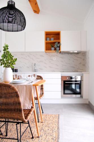 a kitchen with a table and chairs in a room at Verde'Água Family Home in Mosteiros