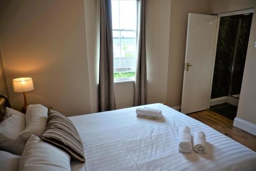 a bedroom with a bed with two pairs of shoes on it at The Angel Hotel in Cardigan