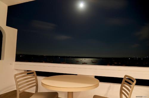 a room with a window with a table and two chairs at Apartamentos Sabina Playa in La Savina