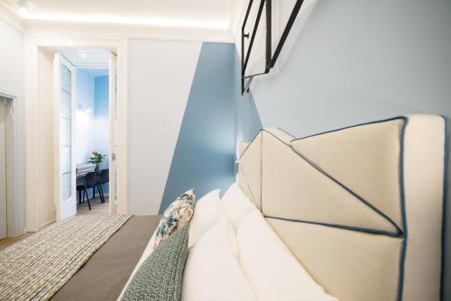 a bedroom with a bed with a blue accent wall at Mediterra in Castellammare di Stabia