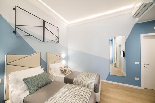 um pequeno quarto com uma cama e um espelho em Mediterra em Castellammare di Stabia