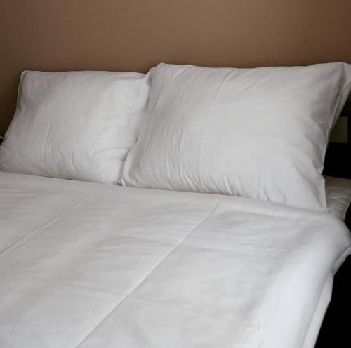 a white bed with white sheets and pillows at Apartmán 224 in Mikulov