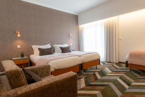 モンテ・レアルにあるD. Afonso Hotel & SPAのベッドとソファ付きのホテルルーム
