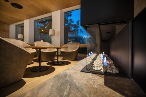 a living room with a fireplace and a table and chairs at Hotel Park - Sava Hotels & Resorts in Bled