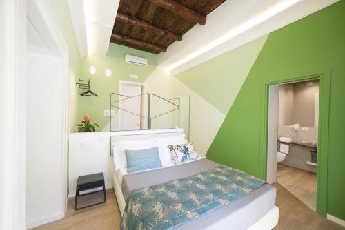 a bedroom with a bed with a green wall at Mediterra in Castellammare di Stabia