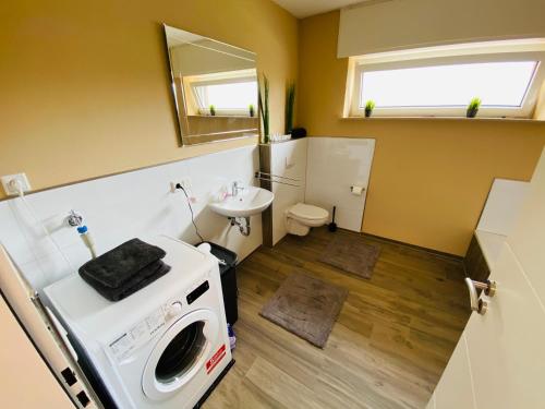 uma pequena casa de banho com uma máquina de lavar roupa e um lavatório em Generous Apartment with own parking Space em Paderborn