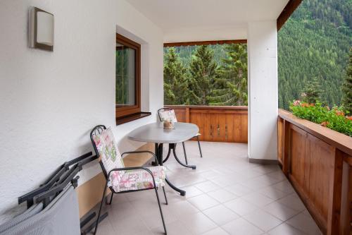 a balcony with a table and chairs and a window at Apart Bel Ami in Kappl
