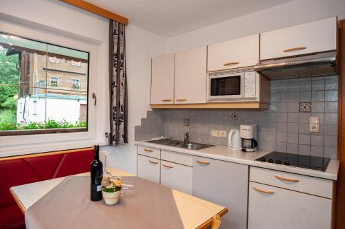 a kitchen with white cabinets and a table and a window at Apart Bel Ami in Kappl
