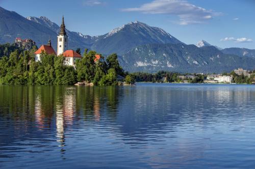 a church on an island in the middle of a lake at Hotel Park - Sava Hotels & Resorts in Bled