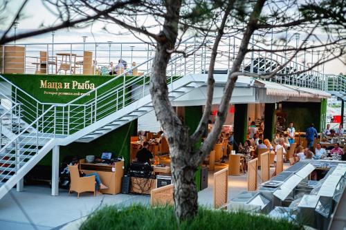 a restaurant with a staircase and people sitting at tables at Maristella Marine Residence in Odesa