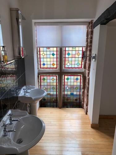 a bathroom with two sinks and a stained glass door at The Silk House in Leek