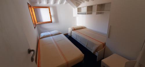 Habitación pequeña con 2 camas y ventana en Villa Violetta, en Castiglioncello