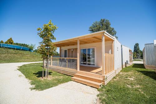 a small house with a deck on the grass at Mediteran Homes with Terme Čatež Tickets in Čatež ob Savi