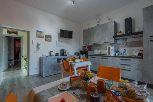 een keuken en eetkamer met een tafel en stoelen bij R&B mediterraneo in Bosa