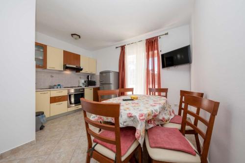 a kitchen with a table with chairs and a table and a table at Paradise Apartments in Lopar