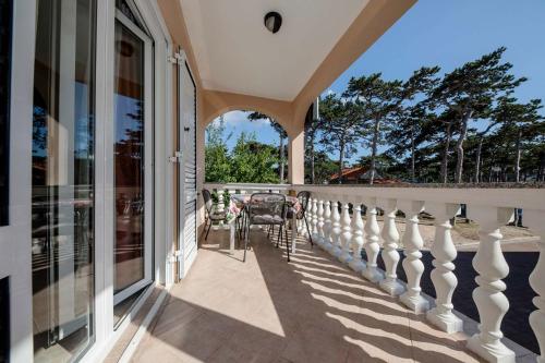 a balcony of a house with a table and chairs at Paradise Apartments in Lopar