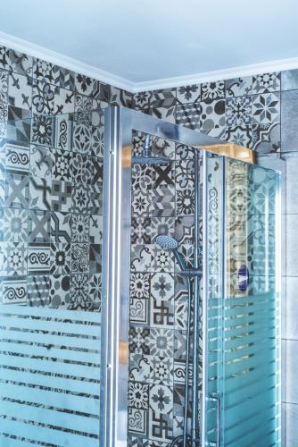 a bathroom with a shower with black and white tiles at Stefania Studios by Estia in Stalís