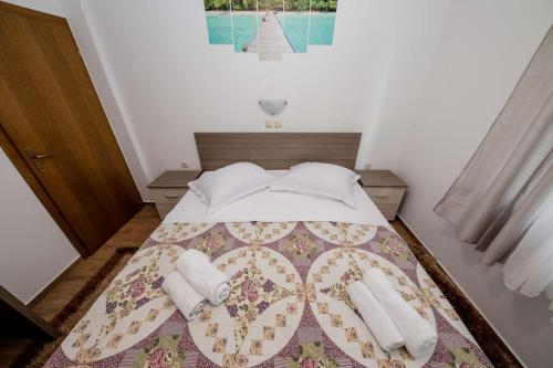 a bedroom with a bed with two towels on it at Paradise Apartments in Lopar