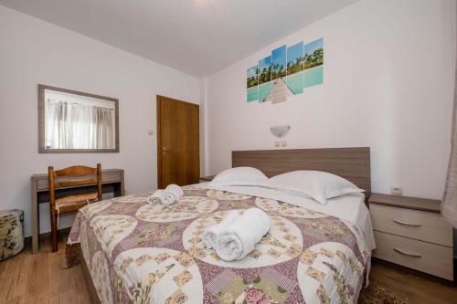 a bedroom with a bed with towels on it at Paradise Apartments in Lopar