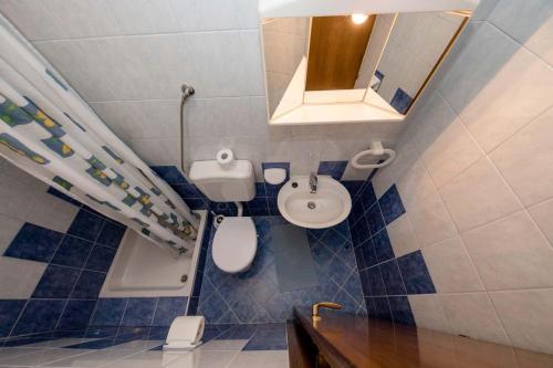 a small bathroom with a toilet and a sink at Paradise Apartments in Lopar