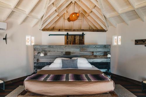 a large bed in a room with a wooden ceiling at Thatch Caye Resort a Muy'Ono Resort in Hopkins