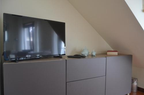uma televisão de ecrã plano em cima de uma cómoda em Casas dos Seixos em Moledo