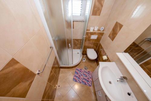 a bathroom with a shower and a toilet and a sink at Paradise Apartments in Lopar