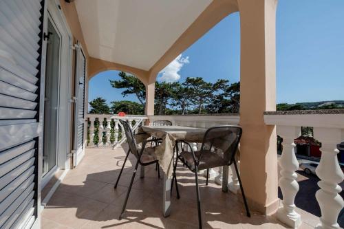 a patio with a table and chairs on a balcony at Paradise Apartments in Lopar