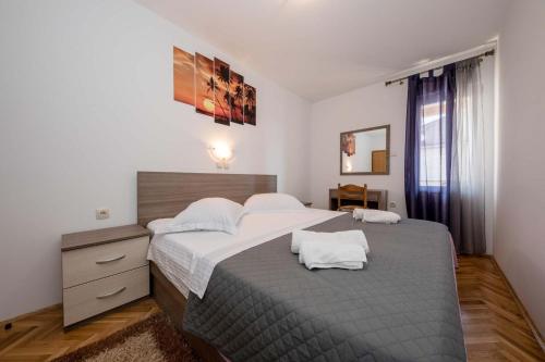 a bedroom with a large bed with two pillows on it at Paradise Apartments in Lopar