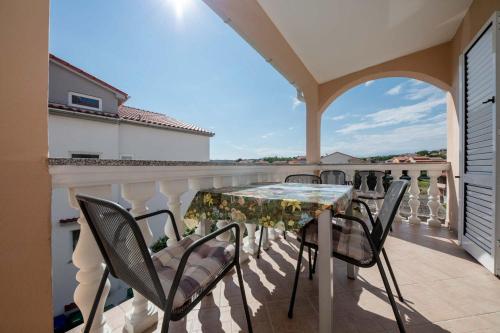 a patio with a table and chairs on a balcony at Paradise Apartments in Lopar