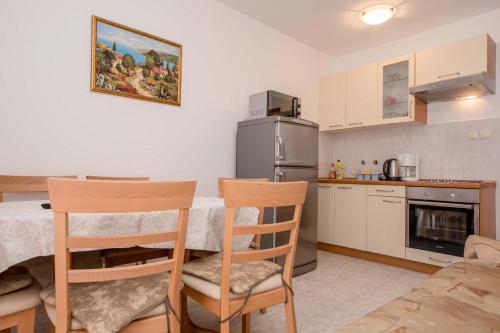 a kitchen with a table and chairs in a room at Paradise Apartments in Lopar