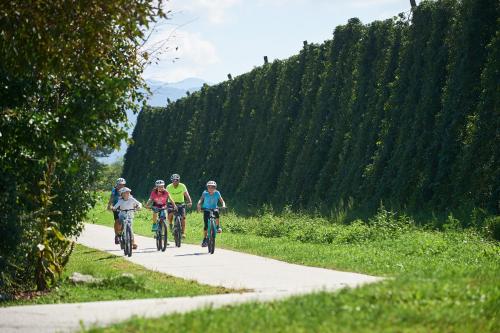 a group of people riding bikes down a road at Hotel Korosica in Šentjanž pri Dravogradu