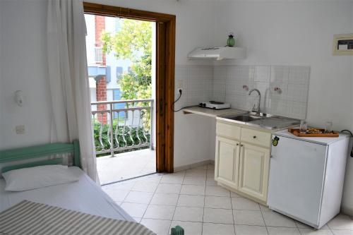 a kitchen with a sink and a door to a balcony at Evaggelou Rooms in Potos