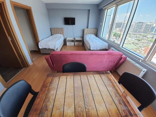 イスタンブールにあるAcademia Residenceのピンクのソファ、テーブル、椅子が備わる客室です。