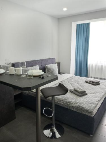 1 dormitorio con 1 cama y 1 mesa con copas de vino en Luxury Central Apartment en Úzhgorod