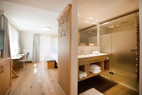 ein Bad mit einem Waschbecken und einem Spiegel in der Unterkunft Hotel Hohes Licht in Damüls