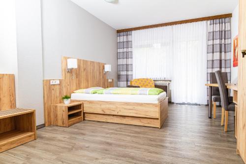a bedroom with a wooden bed in a room at Landhotel Georgshof in Hünfeld