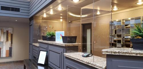 a lobby with a counter with plants on it at Travelway Inn Sudbury in Sudbury