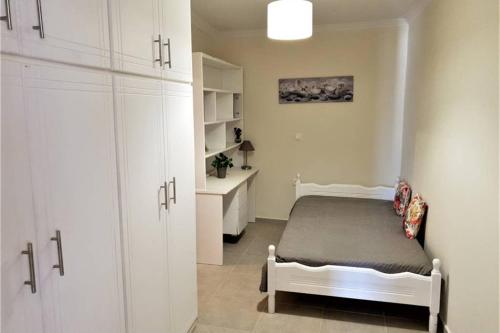 um quarto com uma cama e um armário branco em Villa Rania Loutraki em Loutraki