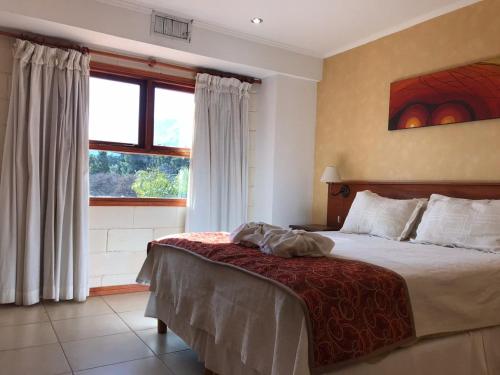 a bedroom with a bed and a large window at Hotel Torres del Sol in Merlo