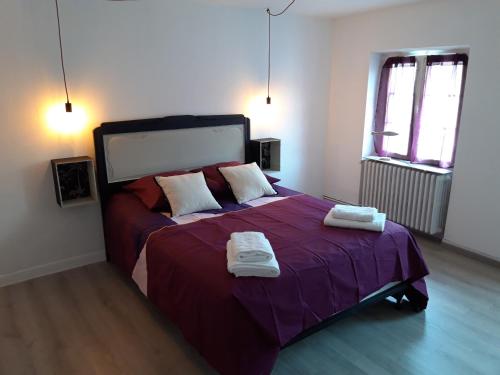 a bedroom with a large bed with two towels on it at Résidence Tivoli in Limoux