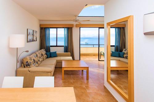 - un salon avec un canapé et une table dans l'établissement SBH Hotel Royal Mónica, à Playa Blanca
