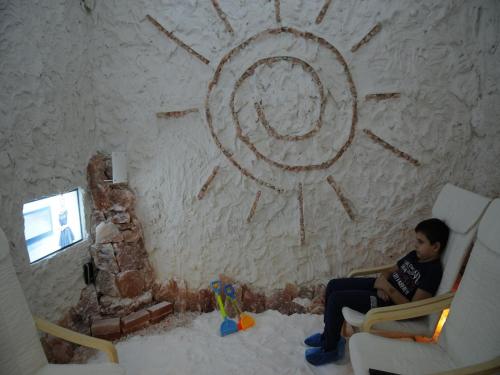 a boy sitting in a chair in front of a wall at Villa i SPA Stević in Veliko Gradište
